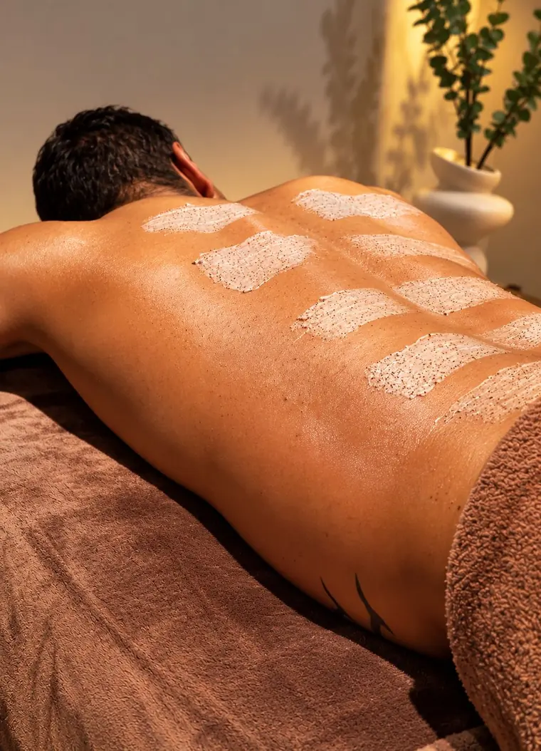 Body scrub applied in sections on a client's back.